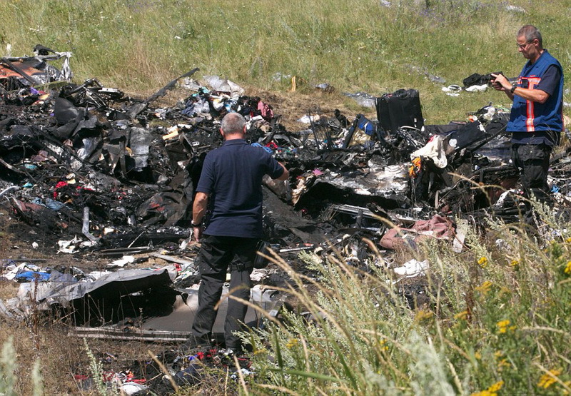 Donetsk Region, Ukraine. 21st July, 2014. Forensic experts at the crash site of a Malaysia Airlines Boeying 777 flight from Amst