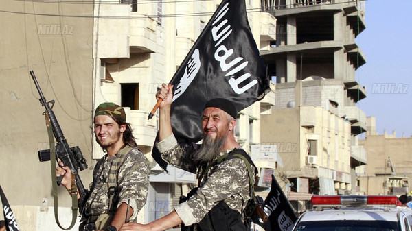 Militant Islamist fighters wave flags as they take part in a military parade along the streets of Syria's northern Raqqa provinc