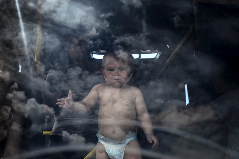 Refugee family and their child in the bus at the border crossing point ( Luhansk region, Ukraine)